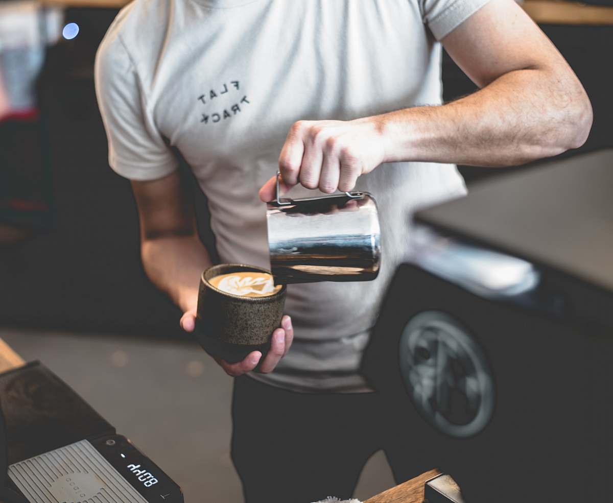 flat track coffee person holding mug austin